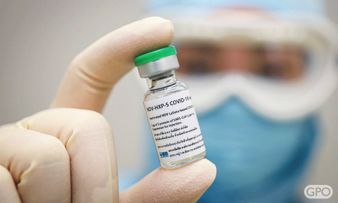 Researcher holding up a vial of COVID Vaccine