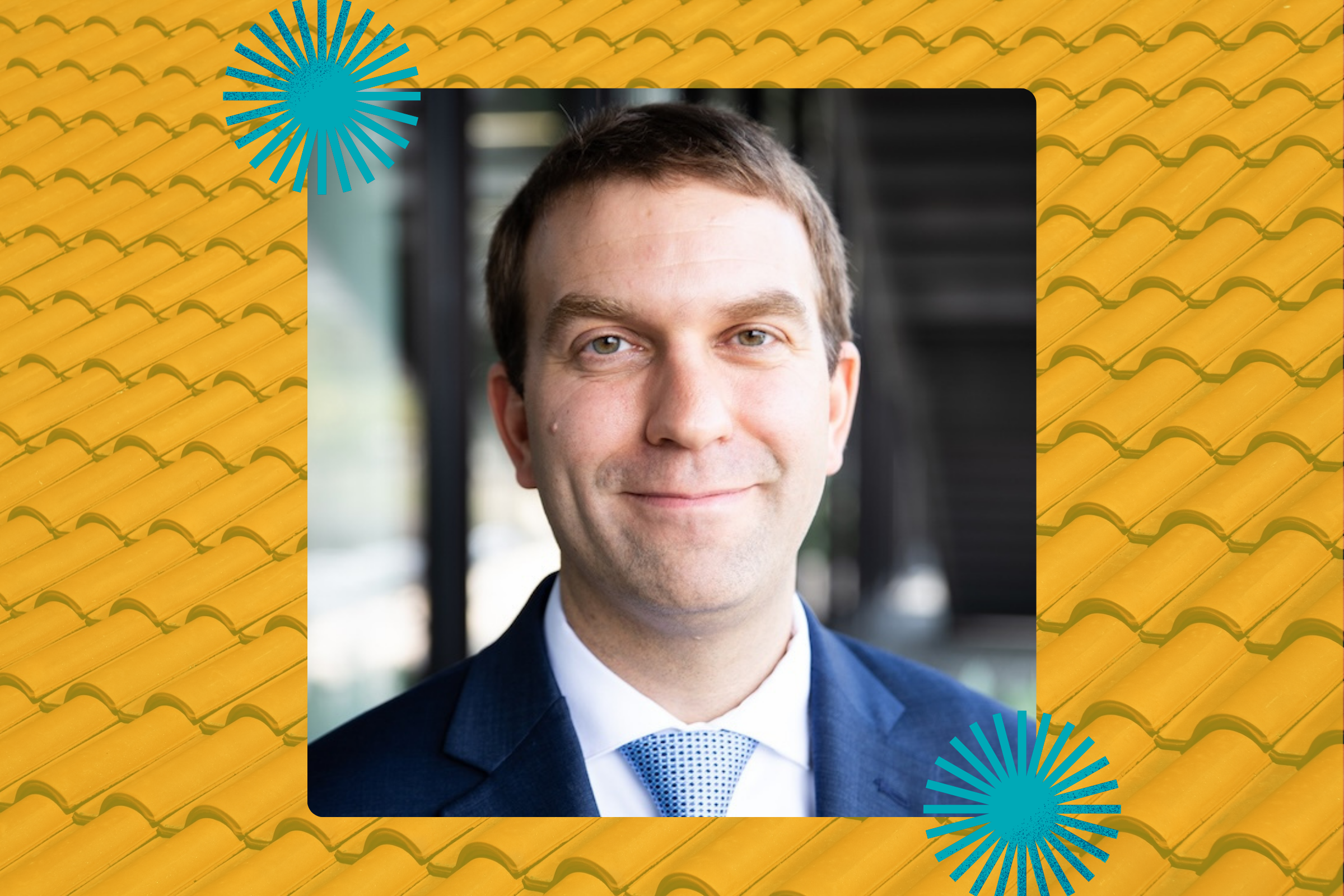 A man in a jacket and tie smiles in a building, while graphic textures frame his photo evoking Spanish tiles and microbes.