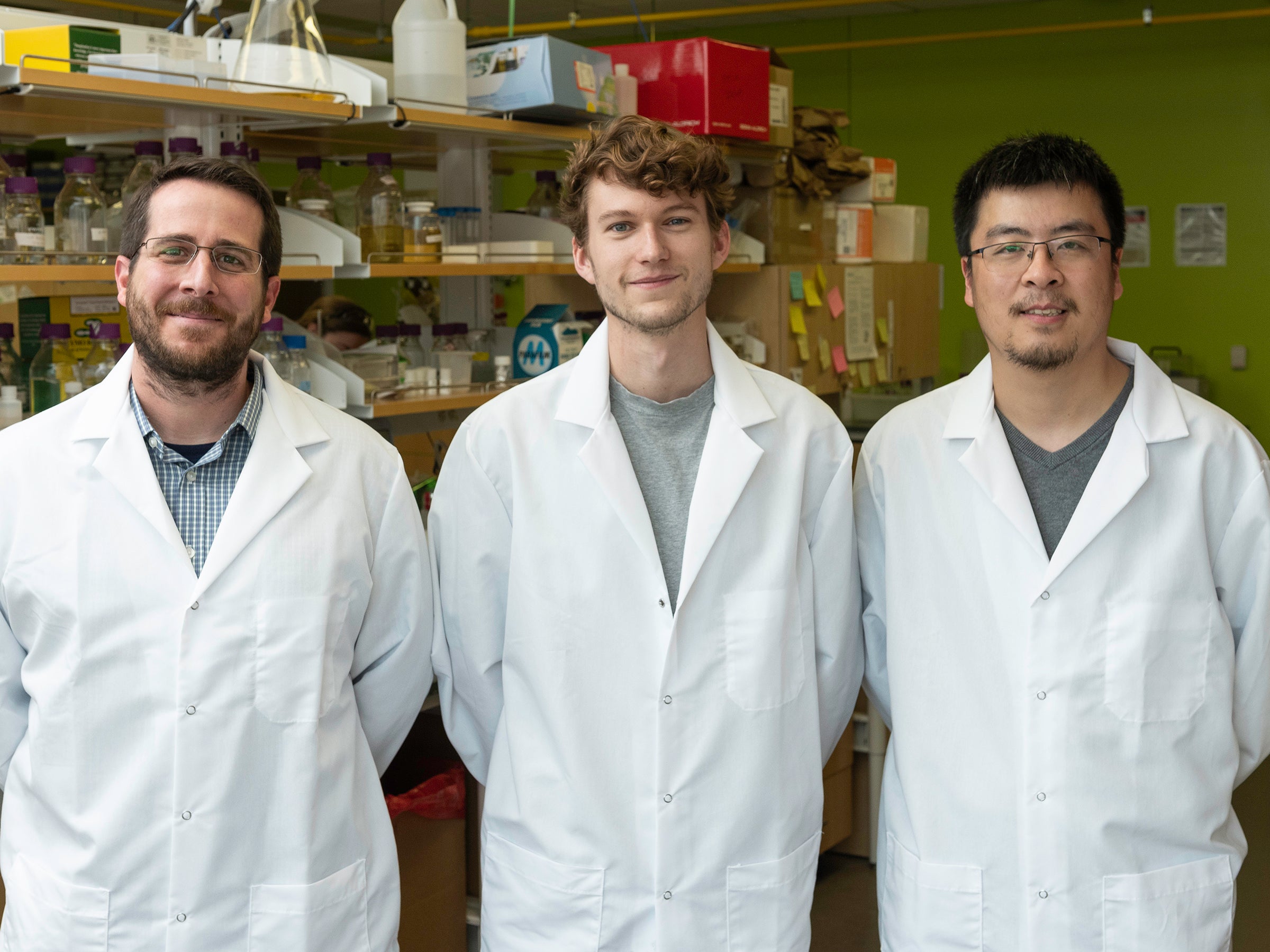 Three scientists in white lab coats